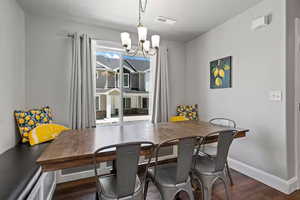 Dining area featuring dark wood-style floors and a chandelier