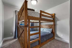 Bedroom featuring carpet and baseboards