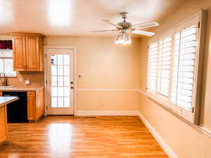 Kitchen featuring light countertops, plenty of natural light, dishwasher, and light wood-type flooring