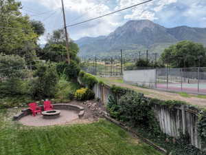 View of yard featuring a patio, park,  mountain view, and a fire pit