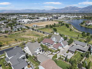 Aerial view of property and surrounding area featuring nearby suburban area and a water and mountain view