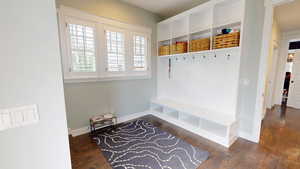 Mudroom with dark wood finished floors and baseboards