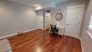 Office space with dark wood finished floors and recessed lighting