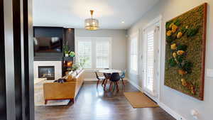 Dining space with dark wood-style flooring, a high end fireplace, recessed lighting, and a chandelier