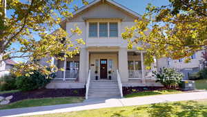 View of front of property with board and batten siding, covered porch, and a ceiling fan