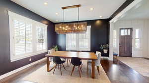 Dining space with dark wood-style floors, recessed lighting, and a chandelier