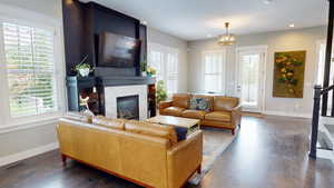 Living area featuring a fireplace, dark wood finished floors, recessed lighting, and a chandelier