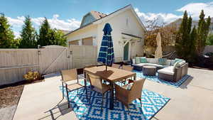 View of patio / terrace with a gate, an outdoor living space, and outdoor dining space