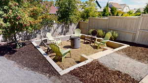 Fenced backyard featuring a fire pit and a patio area