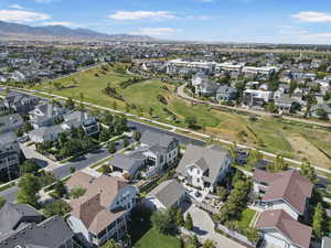 Aerial view of property and surrounding area featuring nearby suburban area and mountains