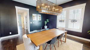 Dining area with dark wood-type flooring, a chandelier, and recessed lighting