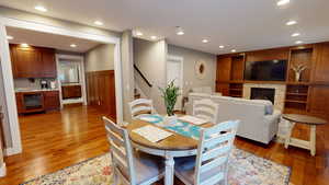 Dining area featuring recessed lighting, a glass covered fireplace, stairs, and light wood-style floors