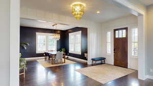 Foyer with a chandelier, dark wood-style floors, and recessed lighting