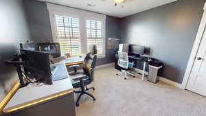 Home office featuring light carpet and baseboards