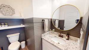 Half bathroom featuring wainscoting and vanity