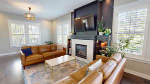 Living room with wood finished floors, a fireplace, and recessed lighting