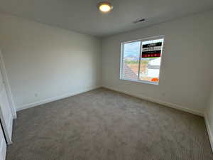 Carpeted spare room with baseboards