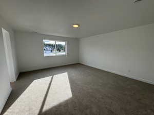 Carpeted spare room with baseboards