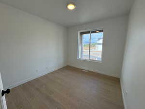 Empty room featuring baseboards and light wood-style floors