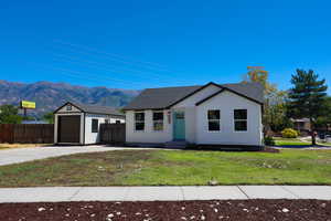 View of front of house with a mountain view, an outbuilding, driveway, and a garage