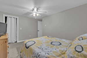 Bedroom with light colored carpet and ceiling fan