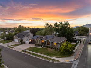 Traditional-style home featuring solar panels, a garage, driveway, and a chimney