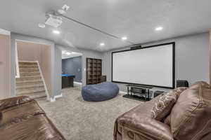 Carpeted home theater featuring recessed lighting and baseboards