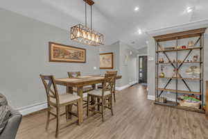 Dining space featuring light wood finished floors, recessed lighting, a baseboard radiator, and vaulted ceiling