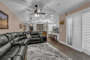 Living room featuring dark wood-style floors, vaulted ceiling, recessed lighting, and a ceiling fan