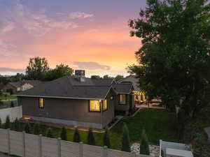 Rear view of house with roof with shingles and a fenced backyard