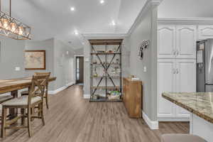Dining room with light wood-style floors, recessed lighting, and crown molding