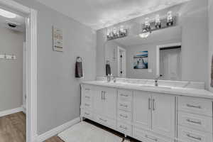 Full bathroom with double vanity and light wood finished floors
