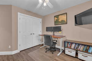 Office area featuring light wood-style flooring and ceiling fan