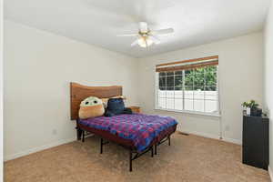 Bedroom with light colored carpet and ceiling fan