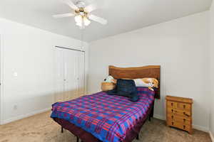 Carpeted bedroom with a closet and a ceiling fan
