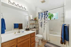 Bathroom featuring shower / tub combo, vanity, and light tile patterned floors