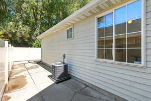 View of side of home featuring a patio and a cooling unit