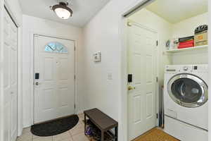 Laundry room featuring washer / clothes dryer and light tile patterned floors
