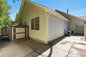 View of home's exterior with a storage unit and a patio