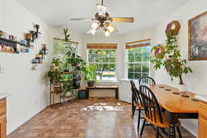 Dining room featuring a ceiling fan and brick patterned floors