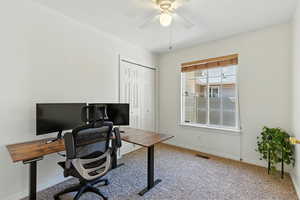 Carpeted home office featuring baseboards