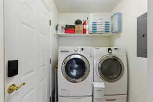 Laundry area featuring washing machine and clothes dryer, electric panel, and a textured ceiling