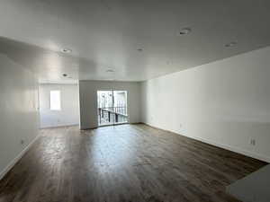 Empty room featuring dark wood-style flooring and recessed lighting