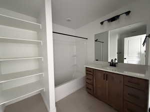 Full bath featuring bathing tub / shower combination, vanity, and light tile patterned floors