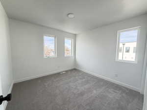 Carpeted empty room with baseboards