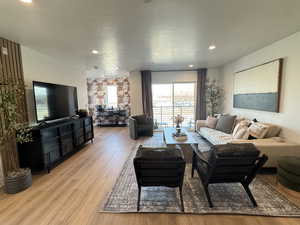 Living area with light wood-type flooring and recessed lighting