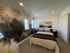 Carpeted bedroom with recessed lighting and a closet