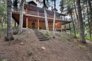Back of property featuring a wooden deck and log veneer siding