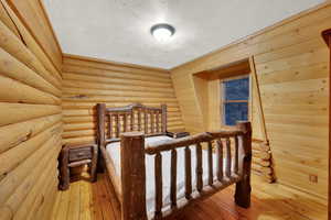 Bedroom featuring a textured ceiling and wood-type flooring
