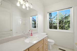Full bathroom featuring vaulted ceiling, vanity, a shower, and a chandelier